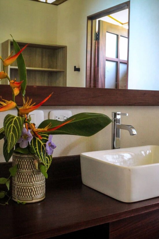 Luxurious bathroom setup with tropical flower arrangement at Villas Azul Ballena.