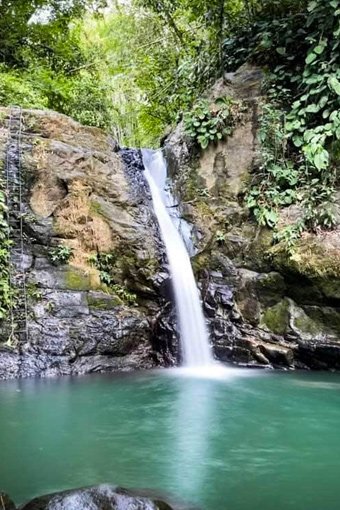 Refreshing waterfall cascading into a natural pool near Villas Azul Ballena.